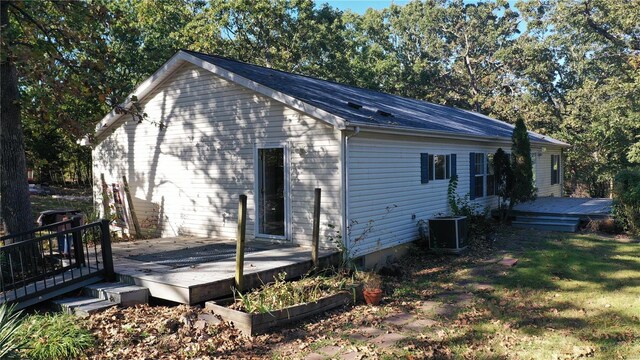 rear view of house with a lawn, a wooden deck, and central AC unit