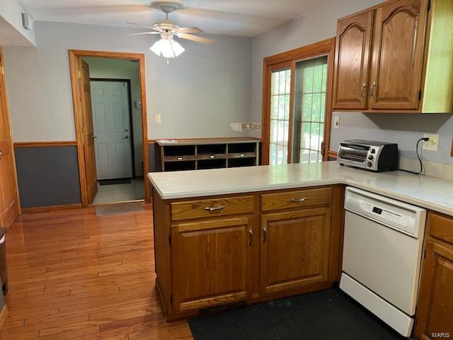 kitchen featuring light wood-type flooring, white dishwasher, kitchen peninsula, and ceiling fan