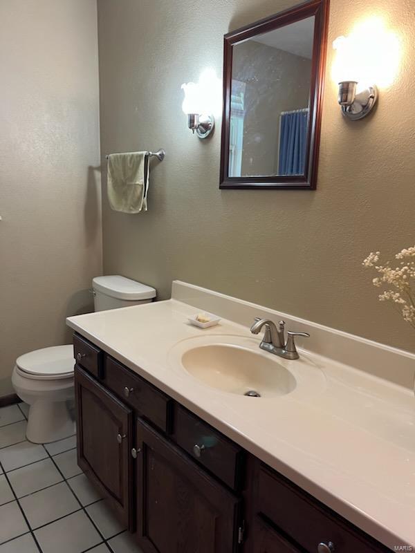 bathroom with vanity, toilet, and tile patterned floors