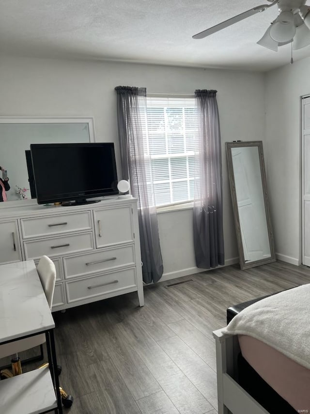 bedroom with hardwood / wood-style floors, a textured ceiling, and ceiling fan