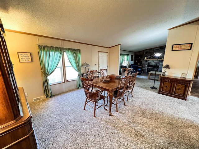 carpeted dining room with a fireplace, crown molding, vaulted ceiling, and a textured ceiling