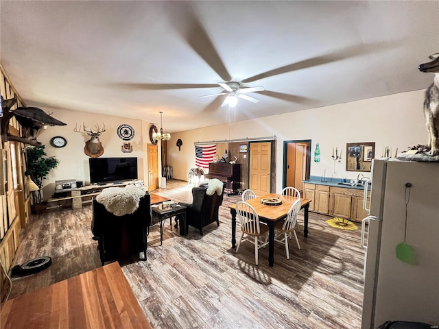 dining area featuring wood-type flooring, sink, and ceiling fan