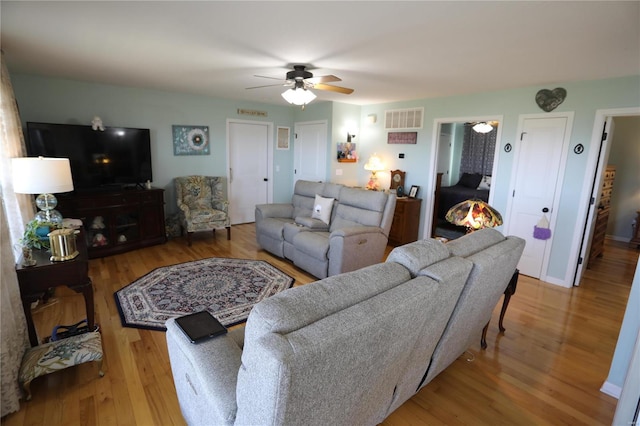 living room featuring ceiling fan and hardwood / wood-style floors