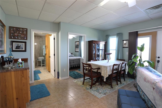 dining room with a paneled ceiling, light tile patterned floors, and ceiling fan