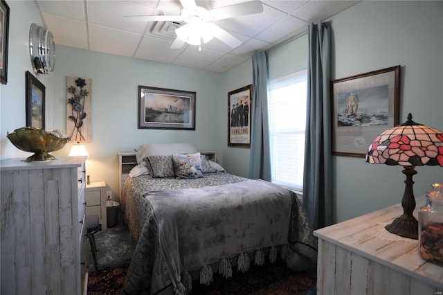 bedroom with a drop ceiling and ceiling fan