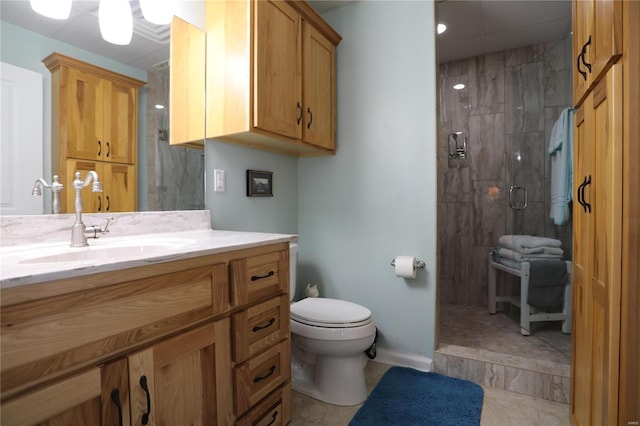 bathroom with vanity, a shower with shower door, toilet, and tile patterned floors