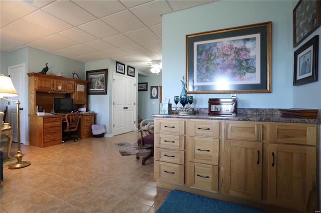 kitchen featuring light tile patterned flooring, a paneled ceiling, and ceiling fan