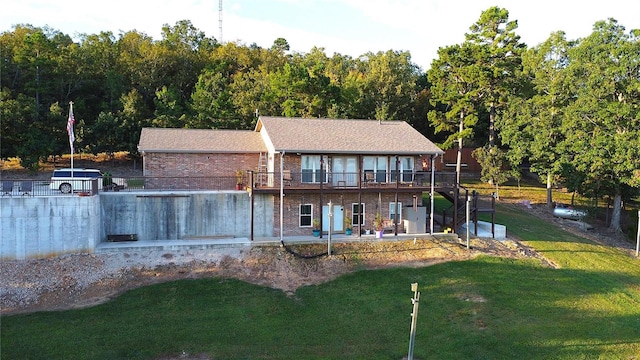 rear view of property featuring a yard, a patio, and a balcony