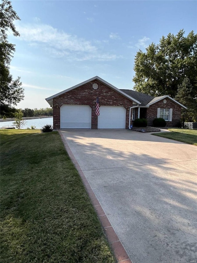 single story home with a water view, a front lawn, and a garage