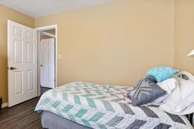 bedroom featuring dark wood-type flooring and a textured ceiling