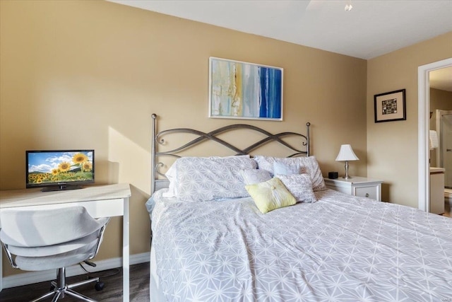 bedroom featuring ensuite bath and dark hardwood / wood-style flooring