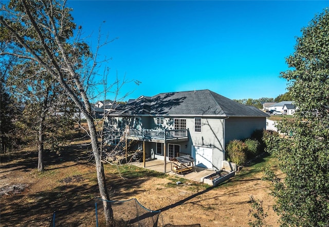 rear view of property featuring a patio area, a lawn, and a wooden deck