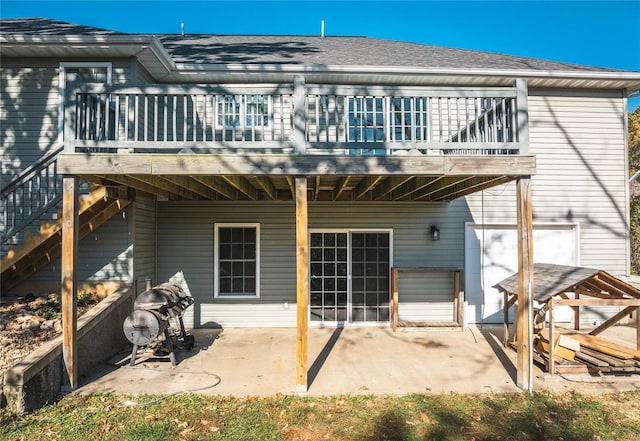 rear view of property featuring a wooden deck and a patio area