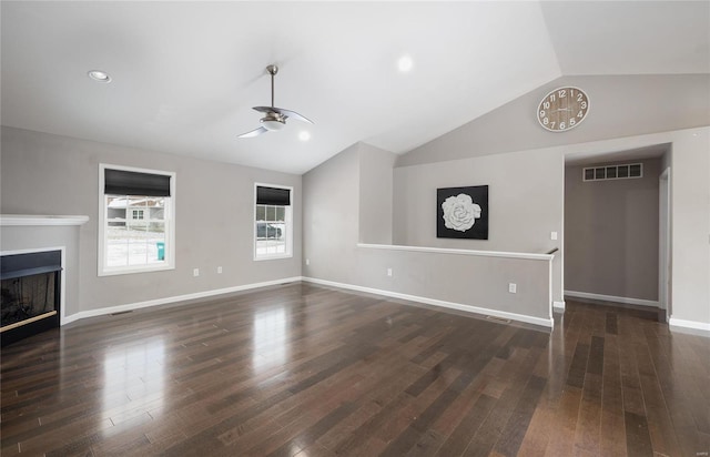 unfurnished living room featuring vaulted ceiling, dark hardwood / wood-style floors, and ceiling fan