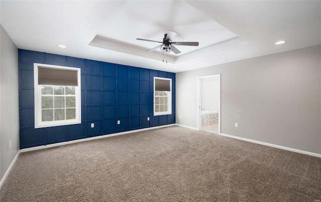 unfurnished room featuring ceiling fan, carpet flooring, and a raised ceiling