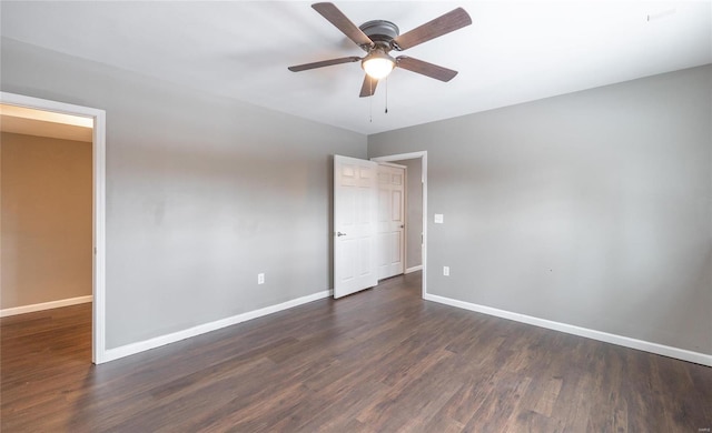 empty room with ceiling fan and dark wood-type flooring