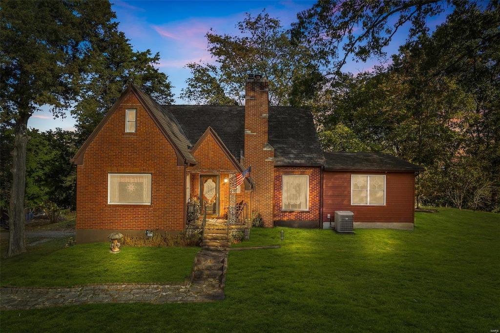 view of front of home featuring a yard and central AC unit