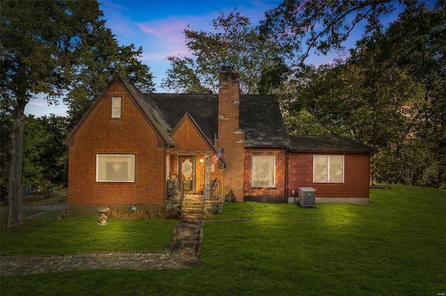 view of front of home featuring a yard and central AC unit