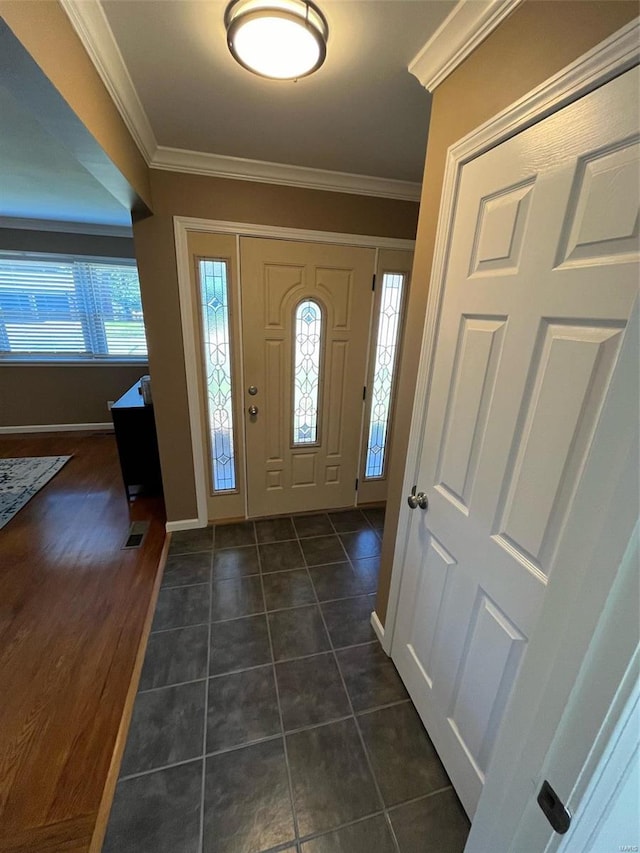 entrance foyer featuring ornamental molding, dark hardwood / wood-style flooring, and plenty of natural light