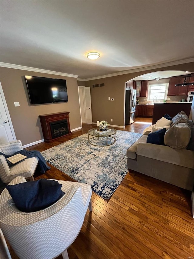 living room with ornamental molding and dark hardwood / wood-style floors