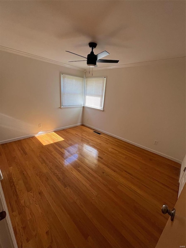 spare room featuring crown molding, light wood-type flooring, and ceiling fan