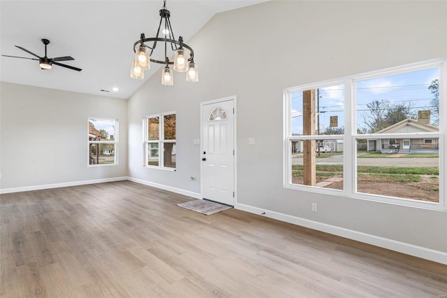 foyer entrance featuring light wood-type flooring, lofted ceiling, and a healthy amount of sunlight