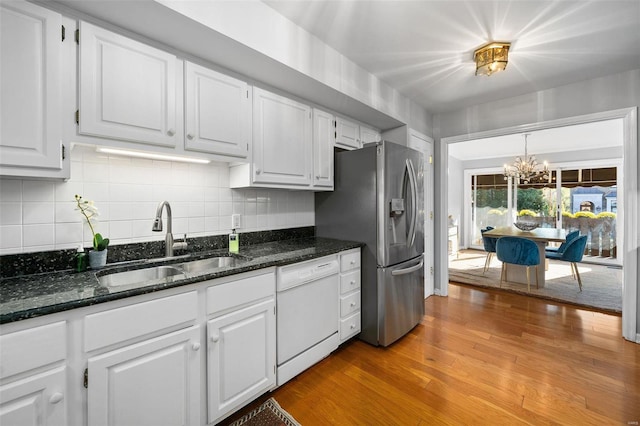 kitchen featuring stainless steel fridge, sink, light hardwood / wood-style floors, white cabinetry, and white dishwasher