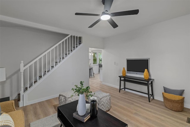 living room with light hardwood / wood-style flooring and ceiling fan