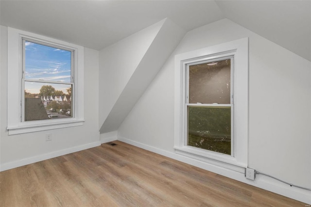 additional living space featuring light hardwood / wood-style flooring and vaulted ceiling