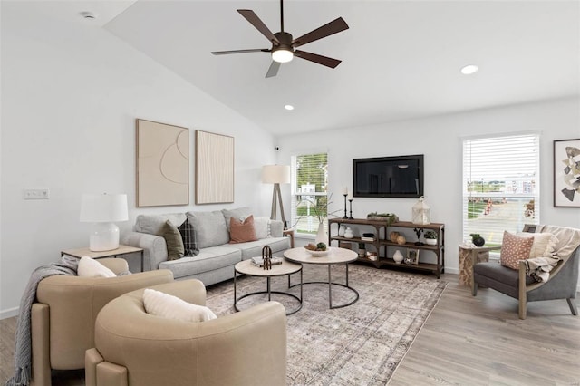 living room with ceiling fan, light hardwood / wood-style flooring, vaulted ceiling, and a healthy amount of sunlight