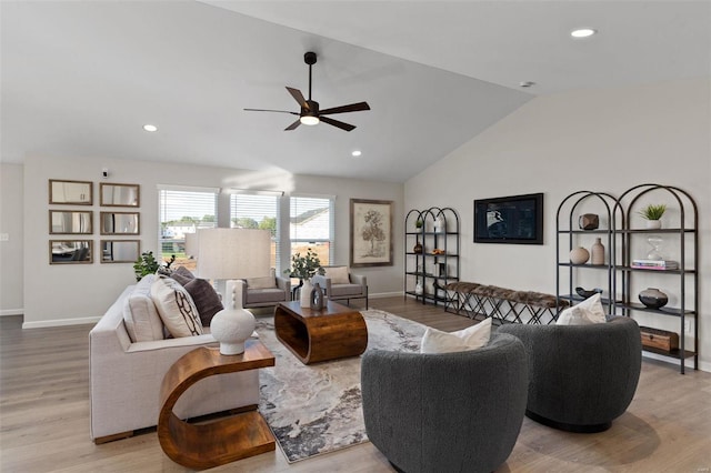 living room with light wood-type flooring, ceiling fan, and vaulted ceiling