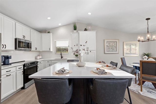 kitchen with a kitchen island, hanging light fixtures, electric stove, and a breakfast bar