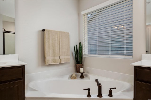 bathroom with independent shower and bath, vanity, and plenty of natural light