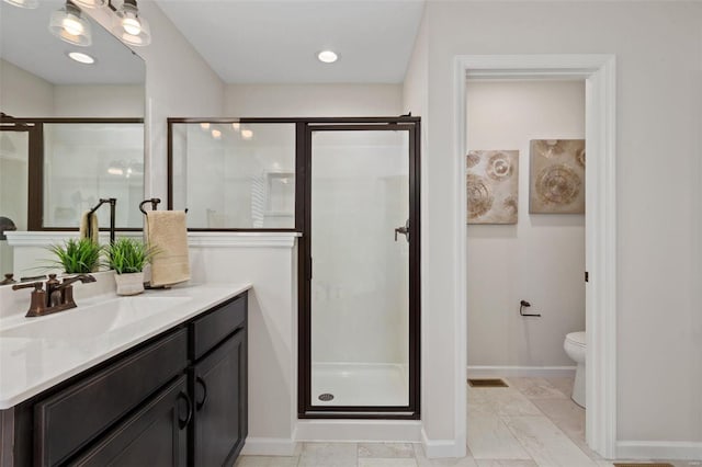 bathroom with vanity, a shower with door, and toilet