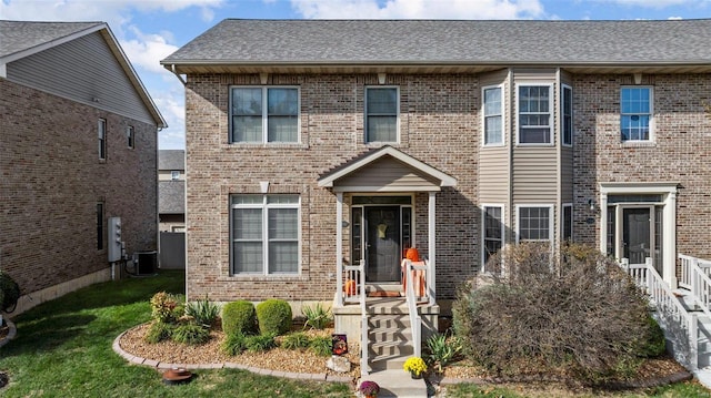 view of front of home featuring cooling unit and a front yard