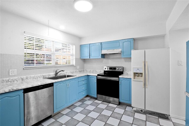 kitchen with appliances with stainless steel finishes, blue cabinetry, tasteful backsplash, and sink