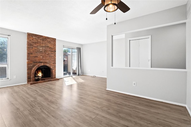 unfurnished living room with a wealth of natural light, hardwood / wood-style floors, a fireplace, and ceiling fan