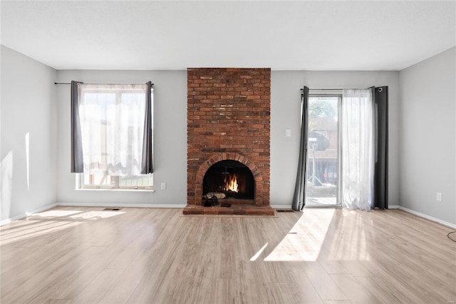 unfurnished living room featuring a fireplace and light hardwood / wood-style floors