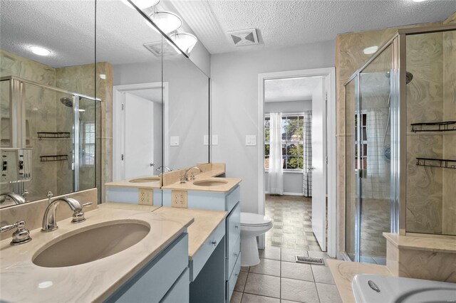 bathroom with vanity, a textured ceiling, and an enclosed shower