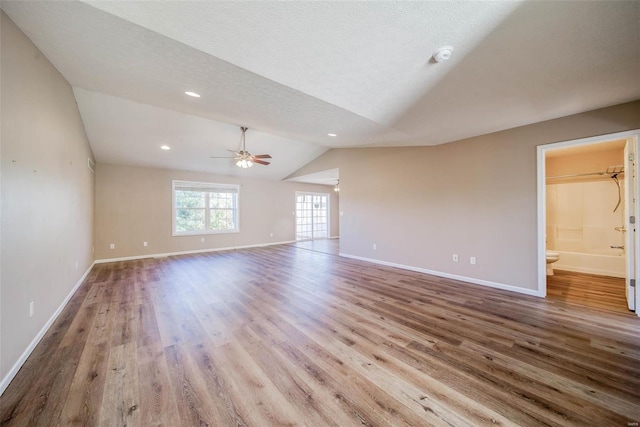 interior space featuring lofted ceiling, a textured ceiling, light wood-type flooring, and ceiling fan