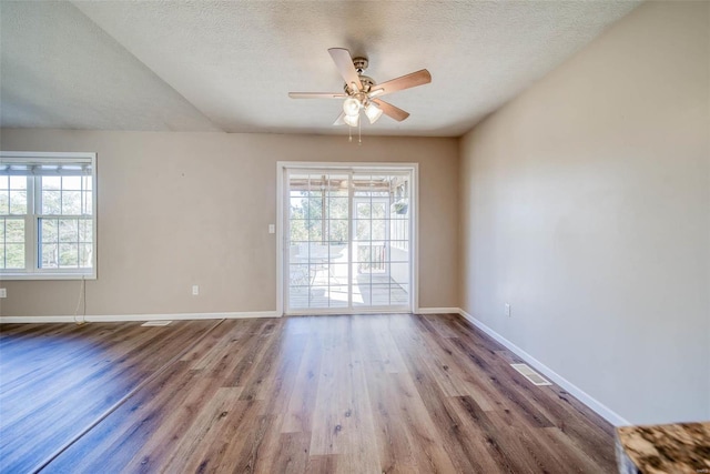 unfurnished room with light hardwood / wood-style flooring, a textured ceiling, a wealth of natural light, and ceiling fan