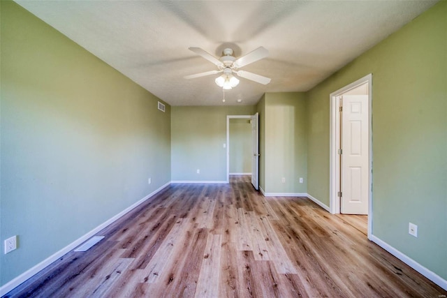 empty room featuring light hardwood / wood-style floors, a textured ceiling, and ceiling fan