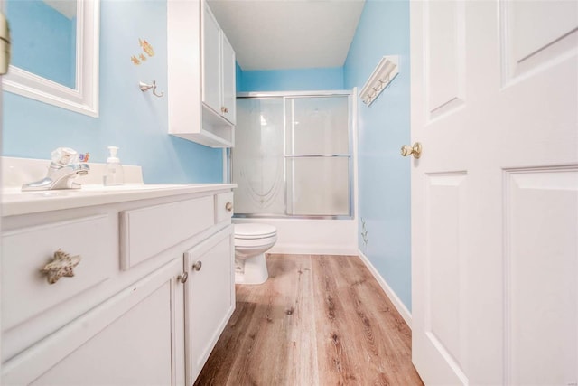 full bathroom with vanity, enclosed tub / shower combo, wood-type flooring, and toilet