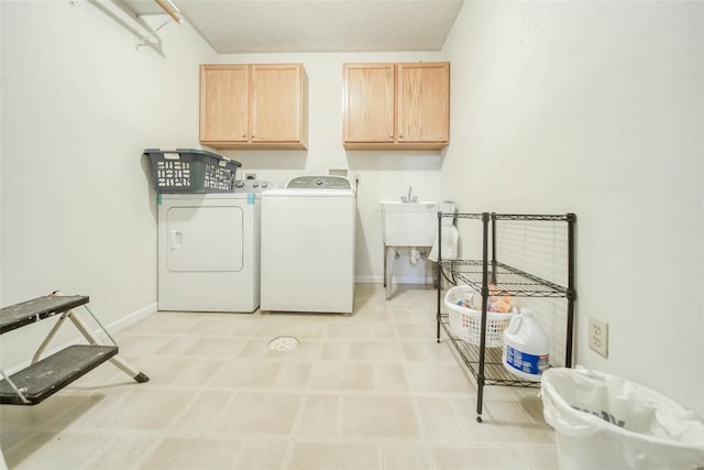 laundry area with cabinets, washer and dryer, and sink