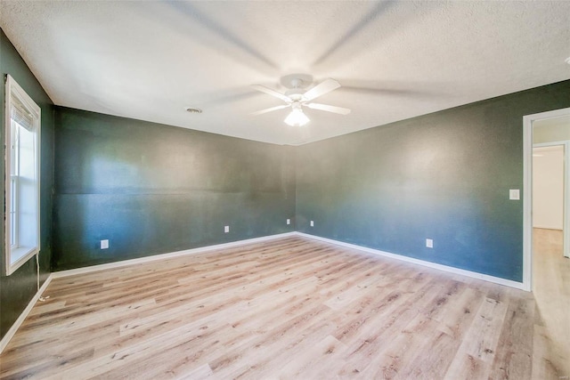 spare room featuring a textured ceiling, light wood-type flooring, and ceiling fan