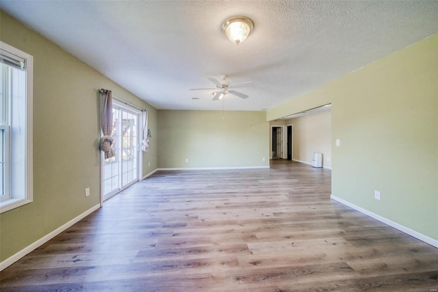 unfurnished room with light hardwood / wood-style flooring, a textured ceiling, and ceiling fan