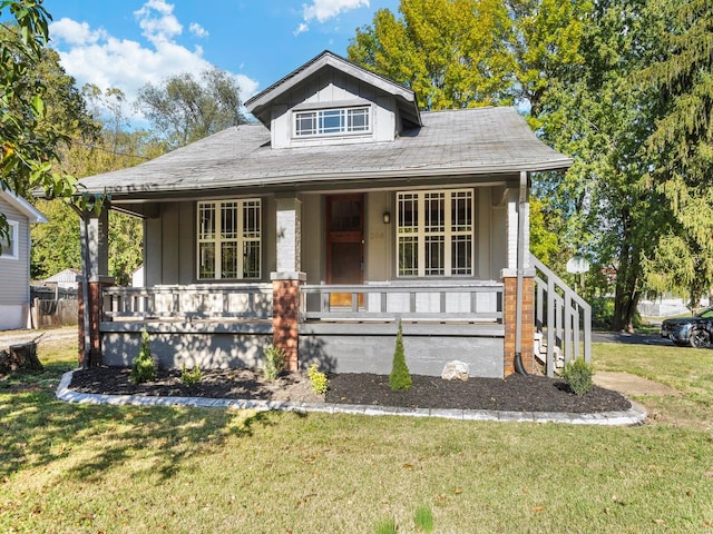 bungalow-style house with covered porch and a front yard