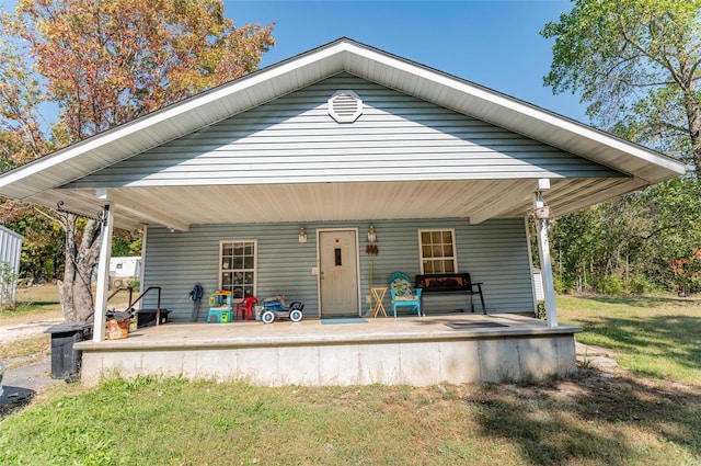 back of house featuring a porch and a lawn