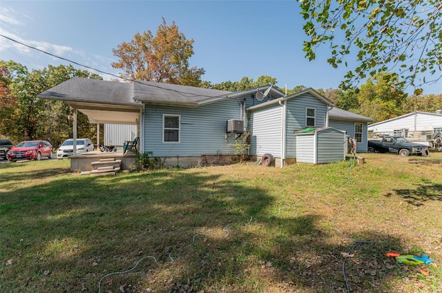 back of house featuring a shed and a lawn