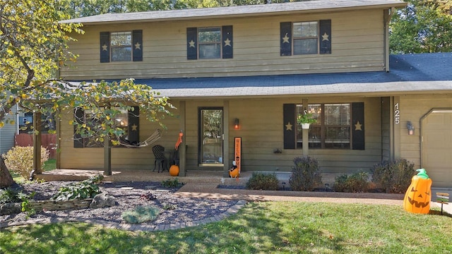 view of front of house with a garage, a porch, and a front yard